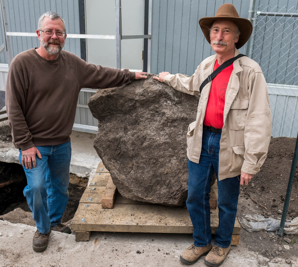 Byron Hueftle-Worley stands by the newly excavated Peace Rock with Grinnell Anthropology Professor John Whittaker. Whittaker supervised students from his Archaeological Field Methods class in conducting the dig. Photo by Justin Hayworth.
