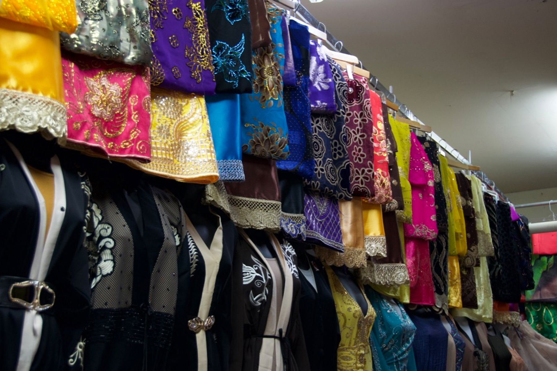 An array of colorful abaya, a style of dress worn by many Muslim women, line one wall of this market stall