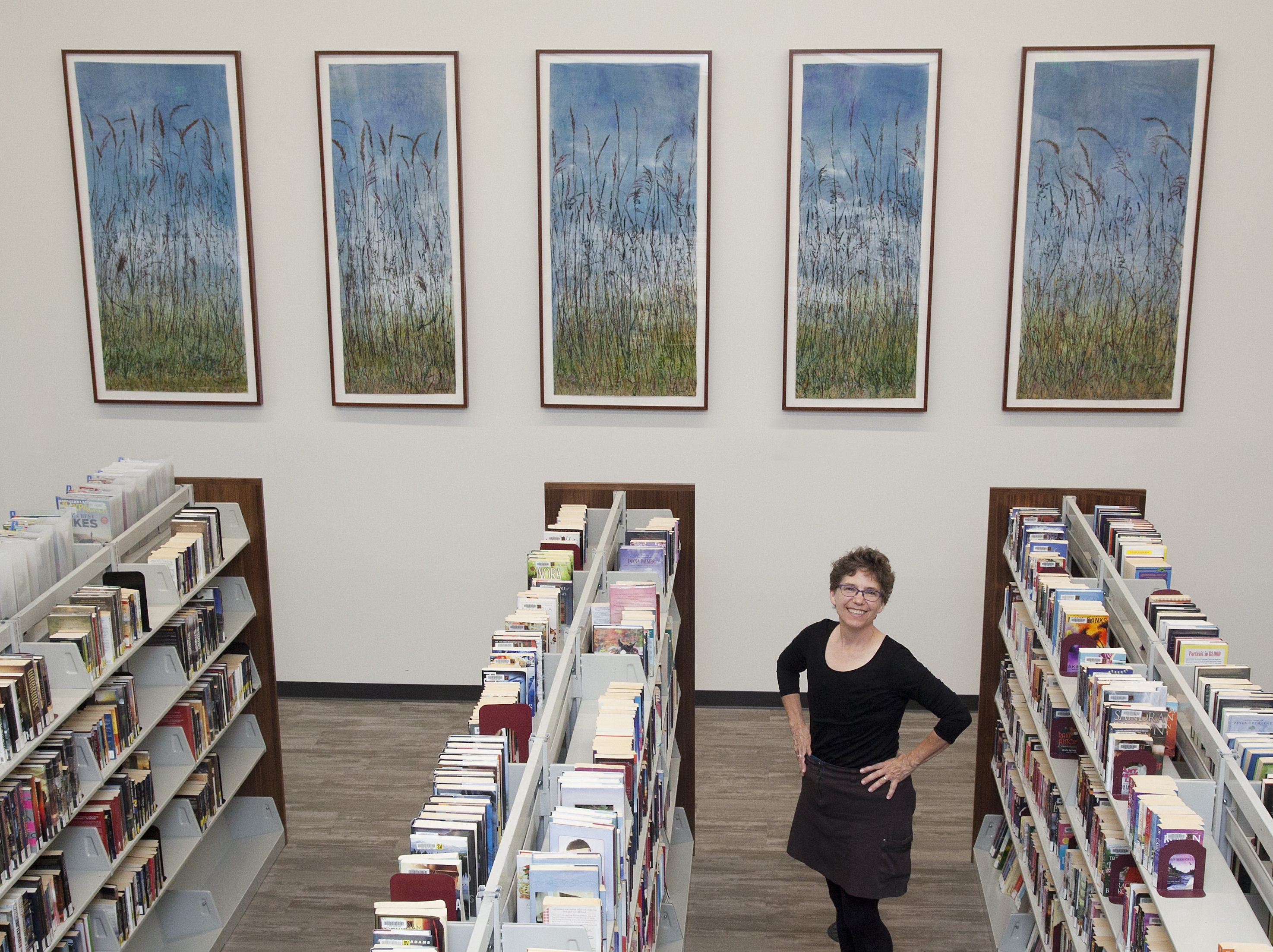Snouffer with her installation, titled *Grass Lake* (botanical printmaking on pigment-infused tissue paper, 2017) at the Shoreview Branch Library in Shoreview, MN. It is her largest piece yet, and is named for a nearby prairie