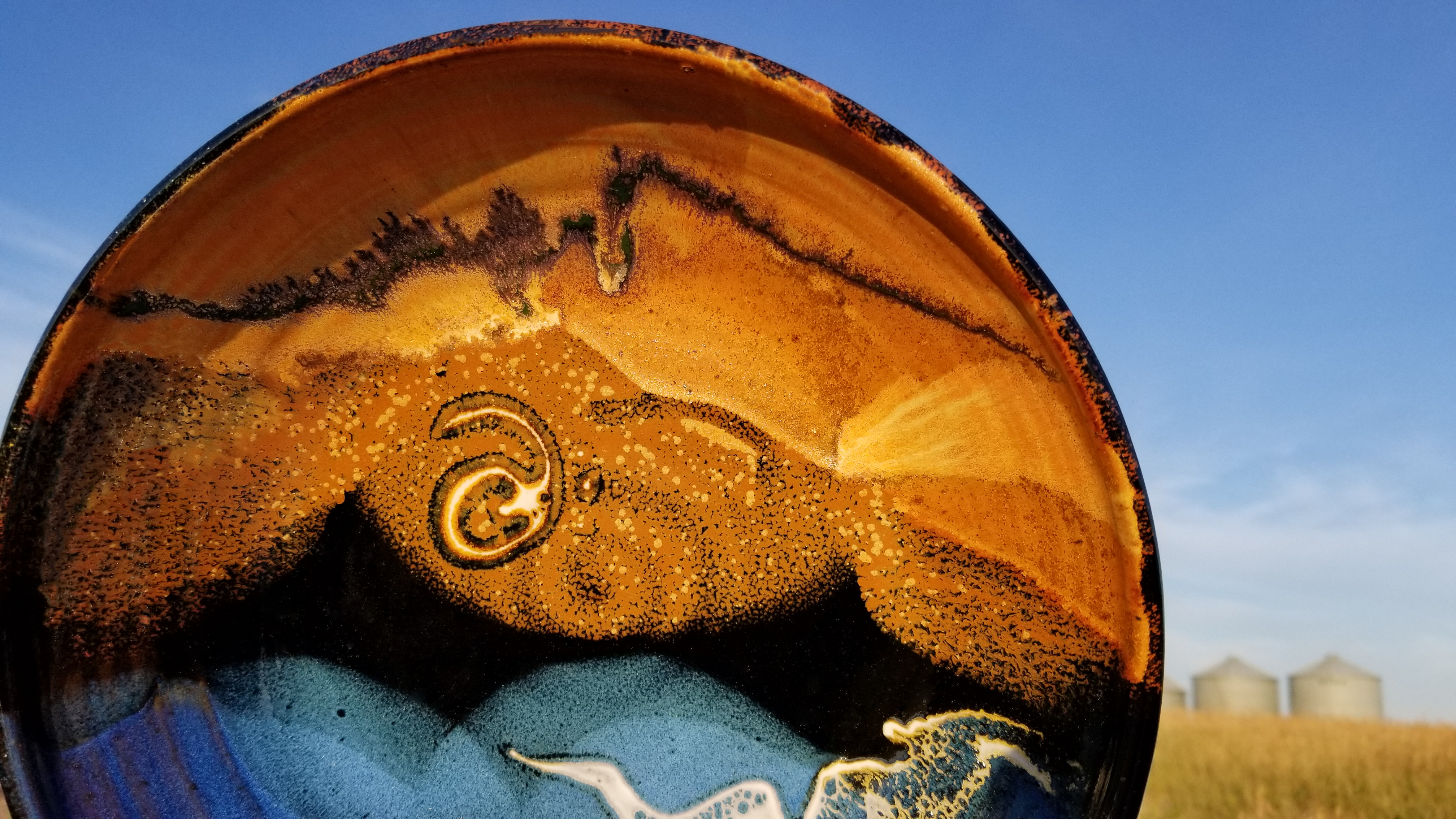A large platter juxtaposed with grain bins near Beach, North Dakota