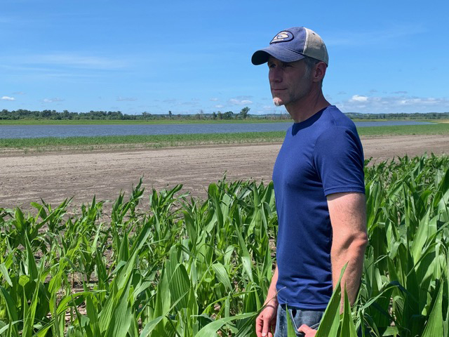Corey McIntosh stands at the edge of Missouri River floodwaters near his home in July 2019. Photo courtesy of Corey McIntosh