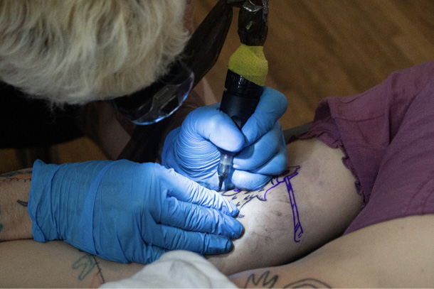 A tatoo design sometimes requires several visits before a it is fully developed, particularly if—as here—Rabalais is working on several tatoos at once. During later sessions, the artist will add detail and color