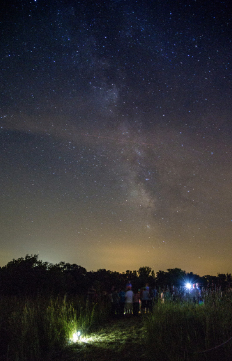 Visitors stand beneath the Milky Way at Grinnell College’s [Conard Environmental Research Area](https://www.grinnell.edu/academics/majors-concentrations/biology/facilities/cera) (CERA).  Photo courtesy of Justin Hayworth