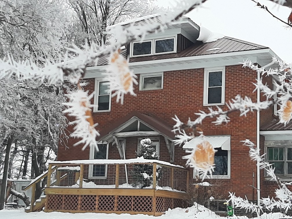 A house with a deck and snow on the ground