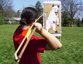 A person throwing an Atlatl at a picture