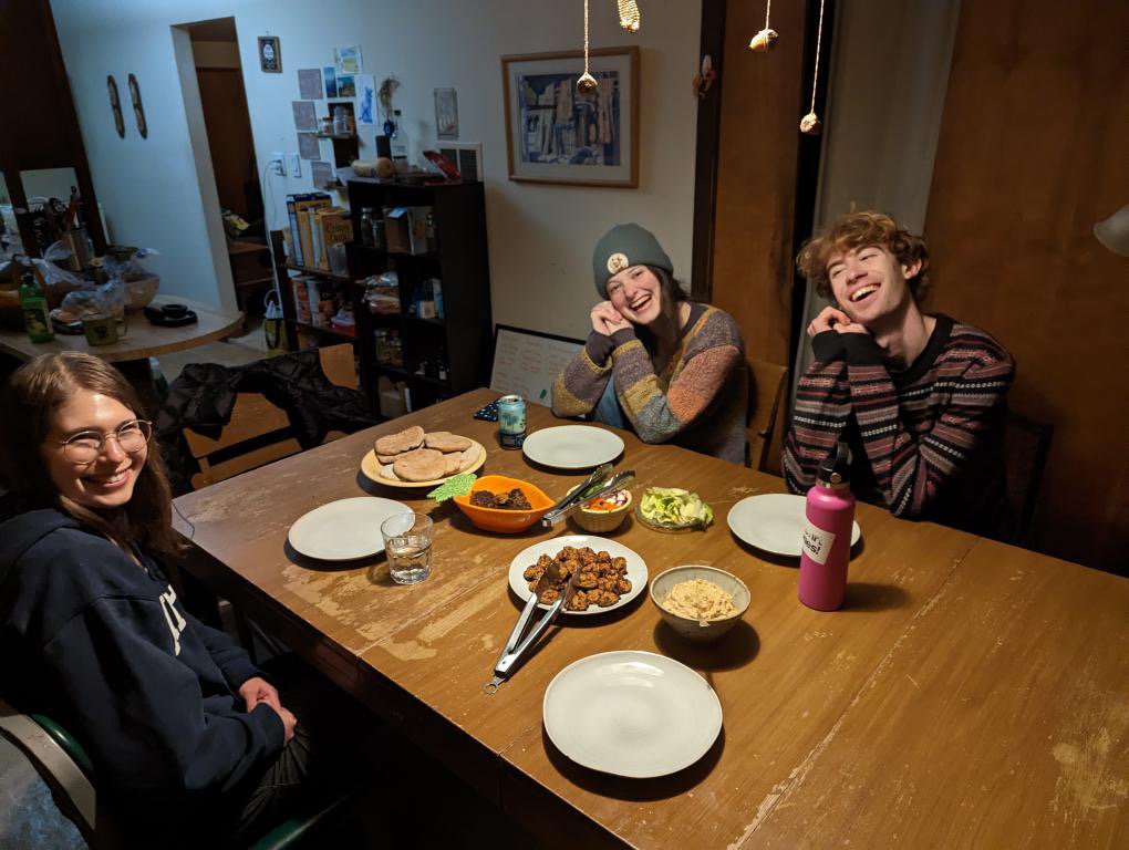 A group of people sitting at a table with plates of food