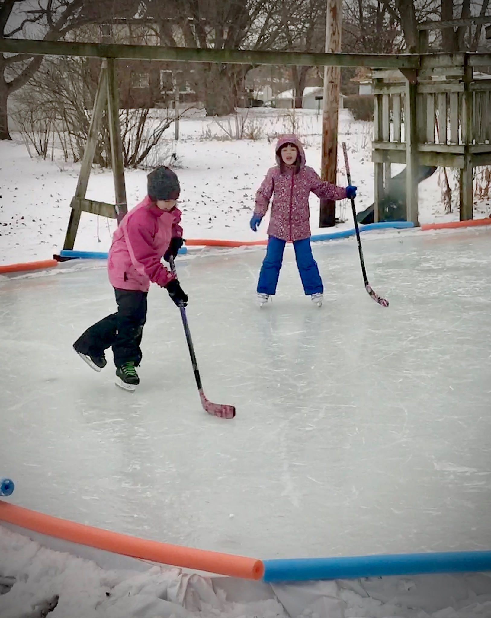 A couple of kids playing ice hockey