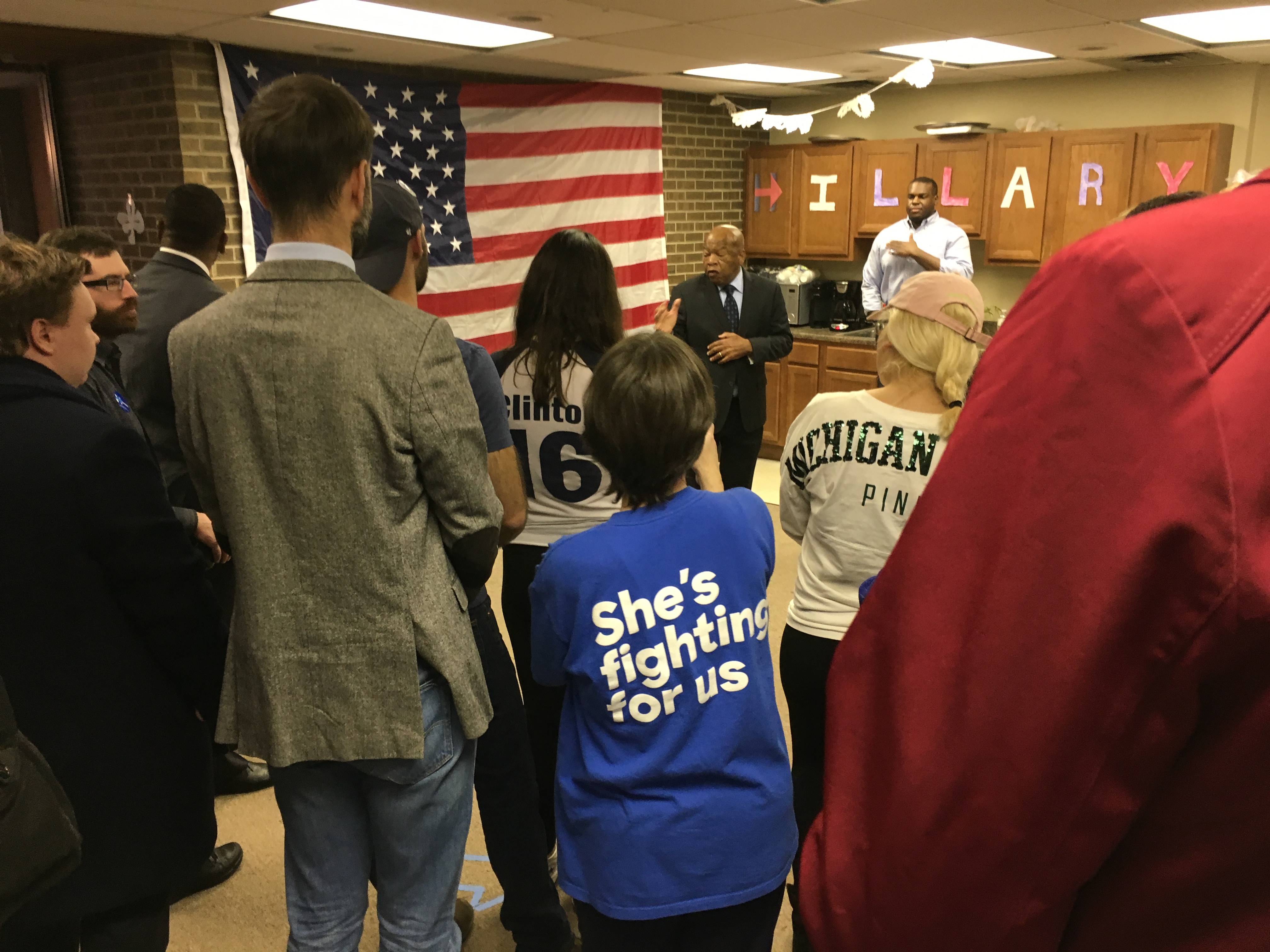 A group of people standing in front of a flag