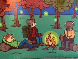 A mural of animals reading books and a campfire